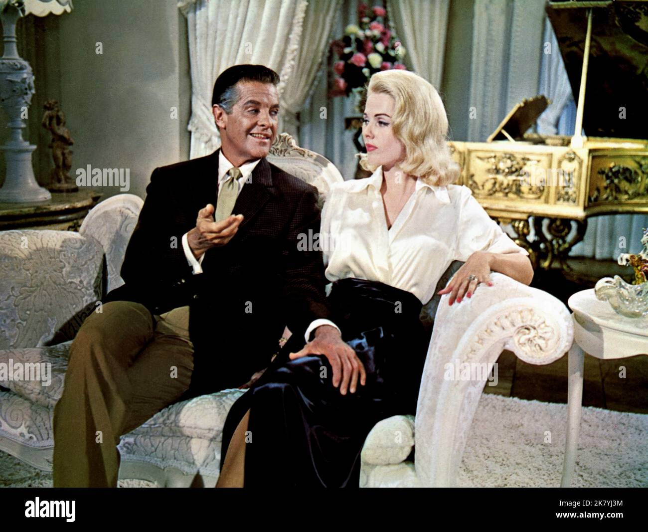 Robert Cummings & Carroll Baker Film The Carpetbaggers (1961) Charaktere: Dan Pierce (als Bob Cummings) & Rina Marlowe Cord Regie: Edward Dmytryk 09. April 1964 **WARNUNG** dieses Foto ist nur für redaktionelle Zwecke bestimmt und unterliegt dem Urheberrecht von PARAMOUNT und/oder dem Fotografen, der von der Film or Production Company zugewiesen wurde. Es ist eine obligatorische Gutschrift bis ÜBERGEORDNETEN BETRAG erforderlich. Der Fotograf sollte ebenfalls angerechnet werden, wenn er bekannt ist. Ohne schriftliche Genehmigung der Film Company kann keine kommerzielle Nutzung gewährt werden. Stockfoto