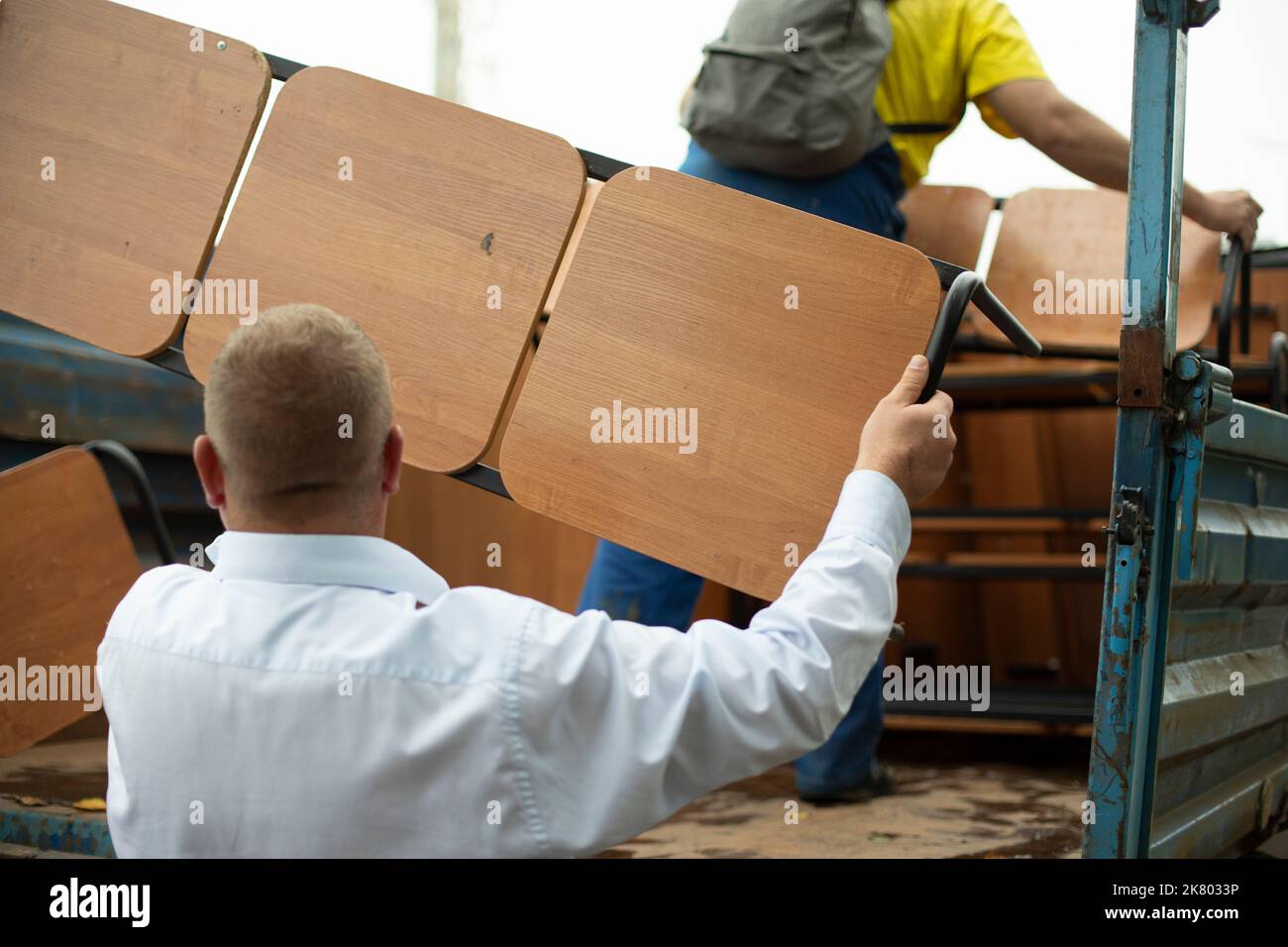 Der Lader hält den Laden. Der Mann stellt eine Bank in den LKW