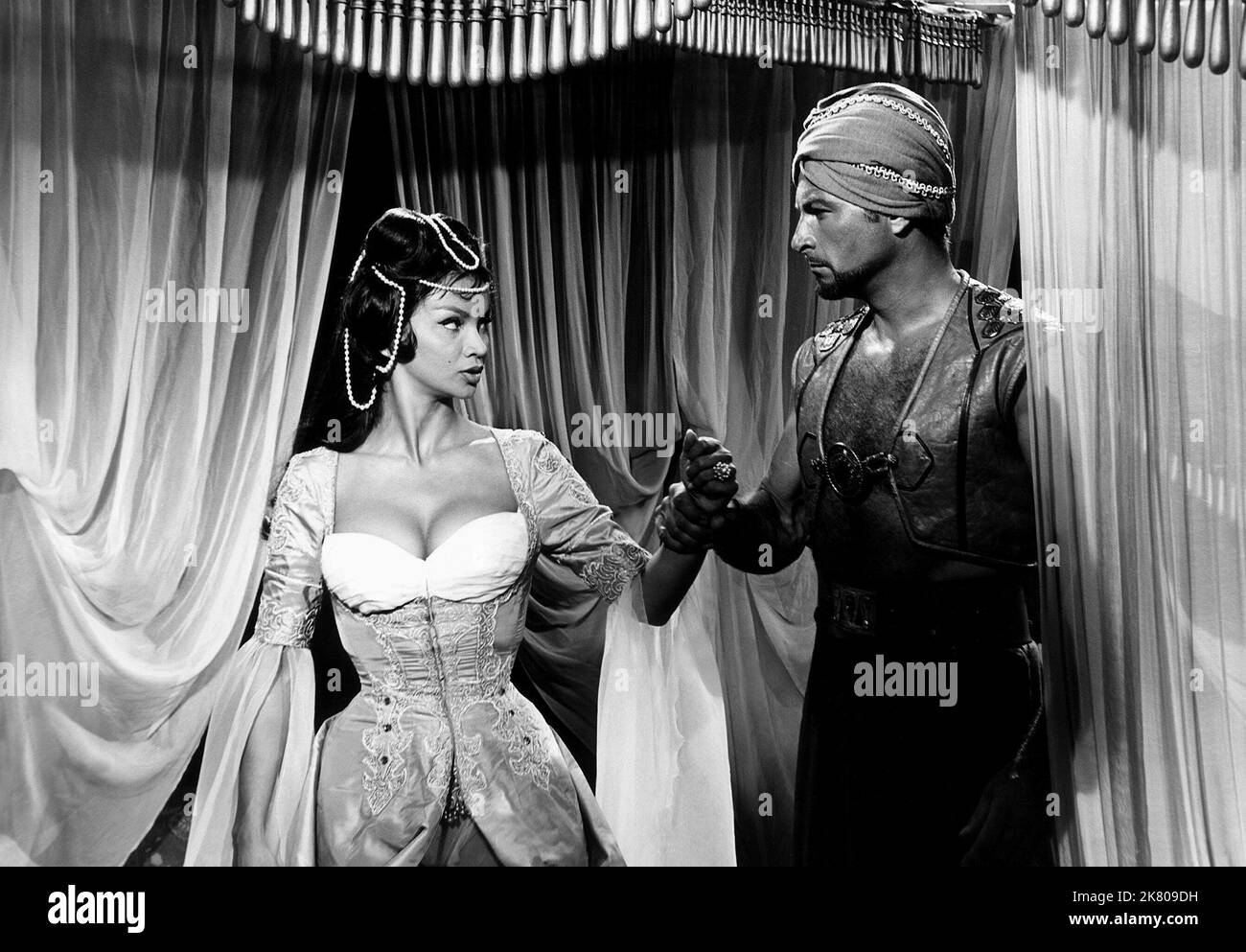 Chelo Alonso & Lex Barker Film: Der Pirat Und Das Sklavenmädchen (1955) Regie: Piero Pierotti 22 October 1959 **WARNUNG** Dieses Foto ist nur für redaktionelle Zwecke bestimmt und unterliegt dem Copyright von CREST und/oder dem Fotografen, der von der Film- oder Produktionsfirma beauftragt wurde und darf nur durch Publikationen im Zusammenhang mit der Bewerbung des oben genannten Films reproduziert werden. Es ist eine obligatorische Gutschrift erforderlich, die für DIE KRETIERUNG erforderlich ist. Der Fotograf sollte auch bei Bekanntwerden des Fotos gutgeschrieben werden. Ohne schriftliche Genehmigung der Film Company kann keine kommerzielle Nutzung gewährt werden. Stockfoto