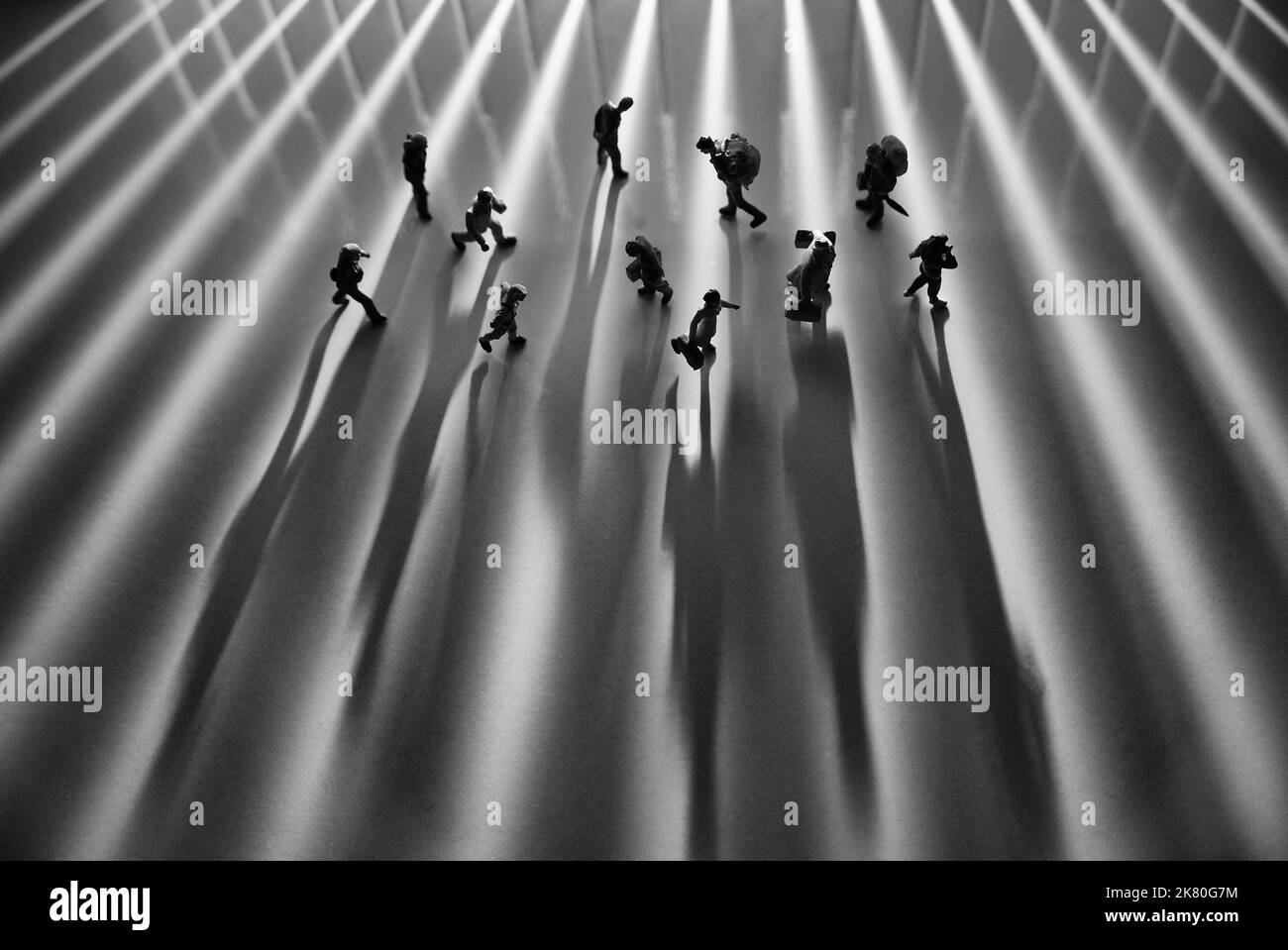 Minifiguren Spielzeug Studio Setup - Draufsicht auf Schwarz-Weiß-Effekt von Menschen mit langen Schatten beschäftigt Wandern während Sonnenaufgang oder Sonnenuntergang. Geräuschentwicklung Stockfoto