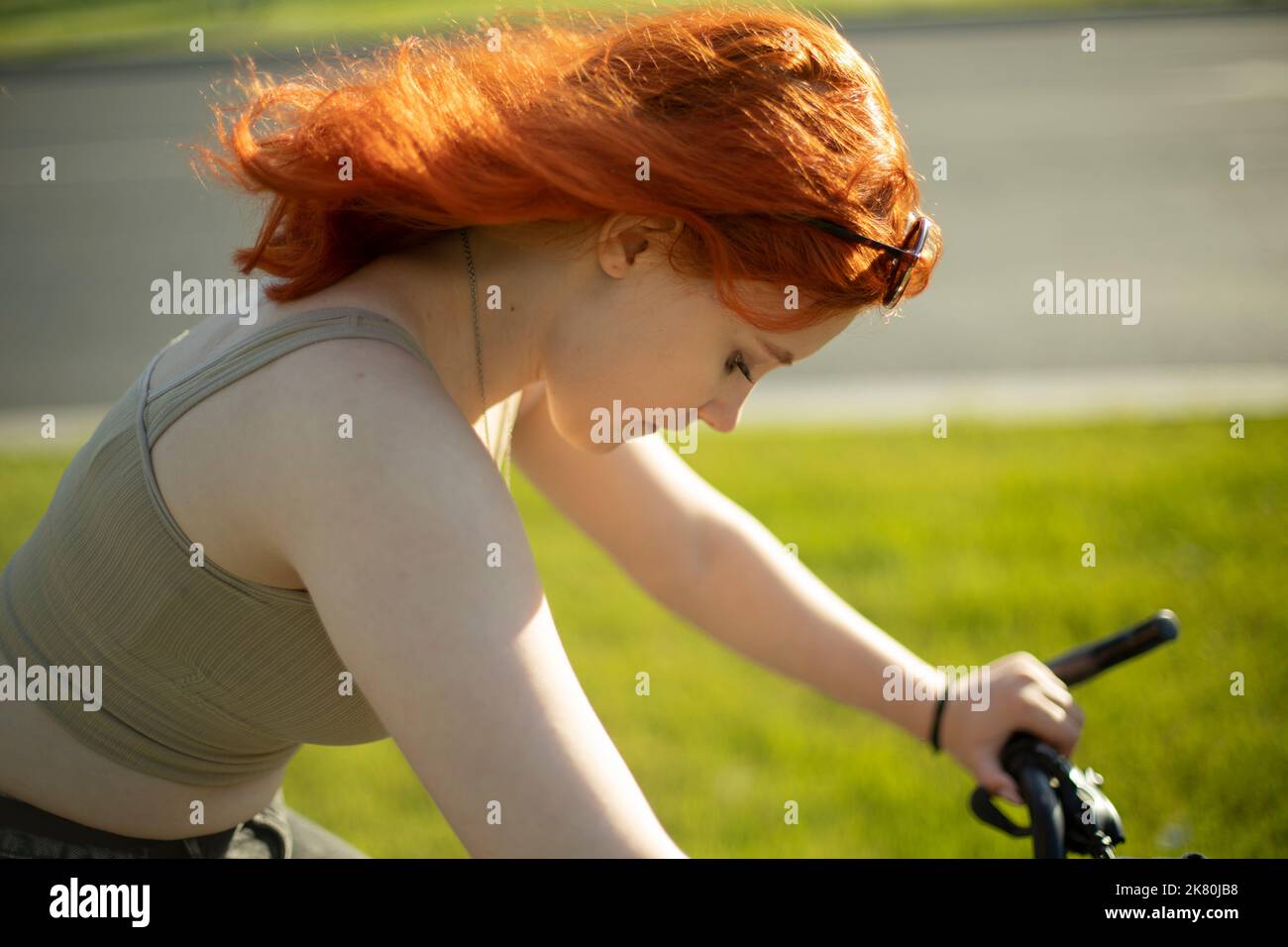 Mädchen fährt Fahrrad. Radfahren. Mädchen beim Schlittschuhlaufen. Tag mit roten Haaren. Stockfoto