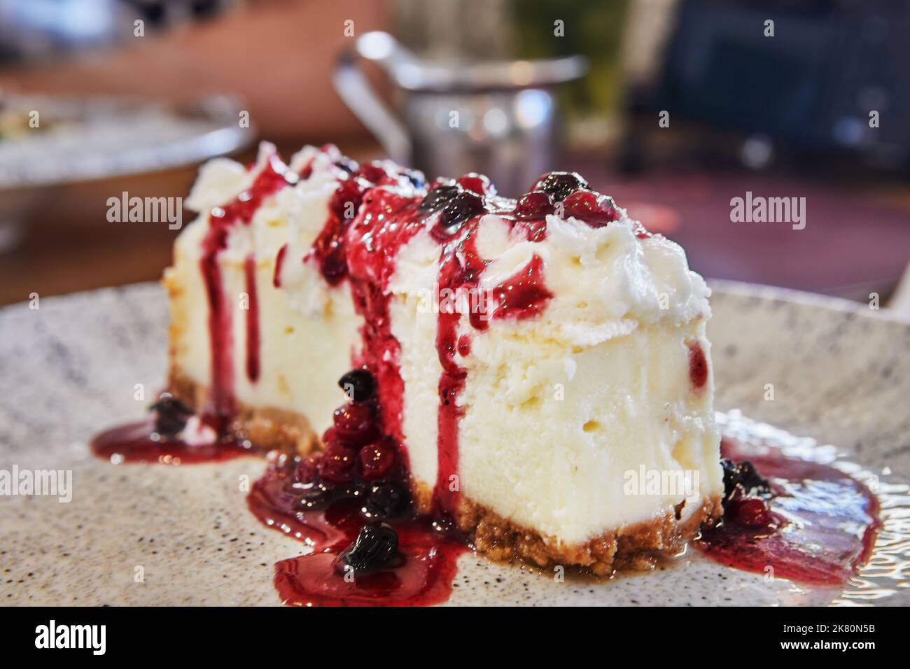 Käsekuchen mit Johannisbeeren und Heidelbeeren in einem café im mediterranen Stil Stockfoto