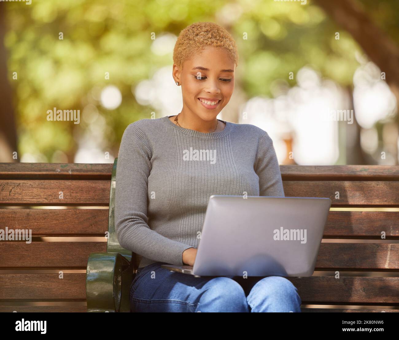 Glückliche schwarze Frau, Laptop und Outdoor Entspannen Sie sich in der Sonne auf der Bank in der Stadt, Online-Jobsuche oder Remote-Arbeit im Park. Junges Mädchen lächelnd, kreativ Stockfoto