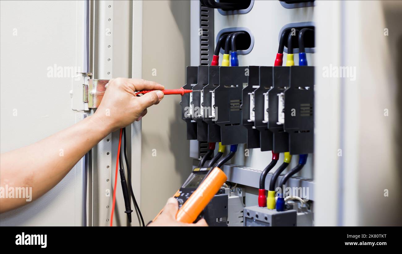 Elektriker Ingenieur Arbeitstester zur Messung der Spannung und des Stroms der elektrischen Stromleitung in der elektrischen Schaltschranksteuerung. Stockfoto