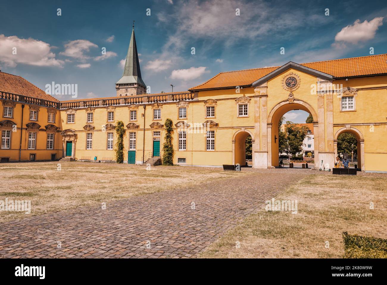 24. Juli 2022, Osnabruck, Deutschland: Eingangstore mit Uhr an der berühmten europäischen Universität in einem schönen gelben Palastgebäude im Barockbogen Stockfoto