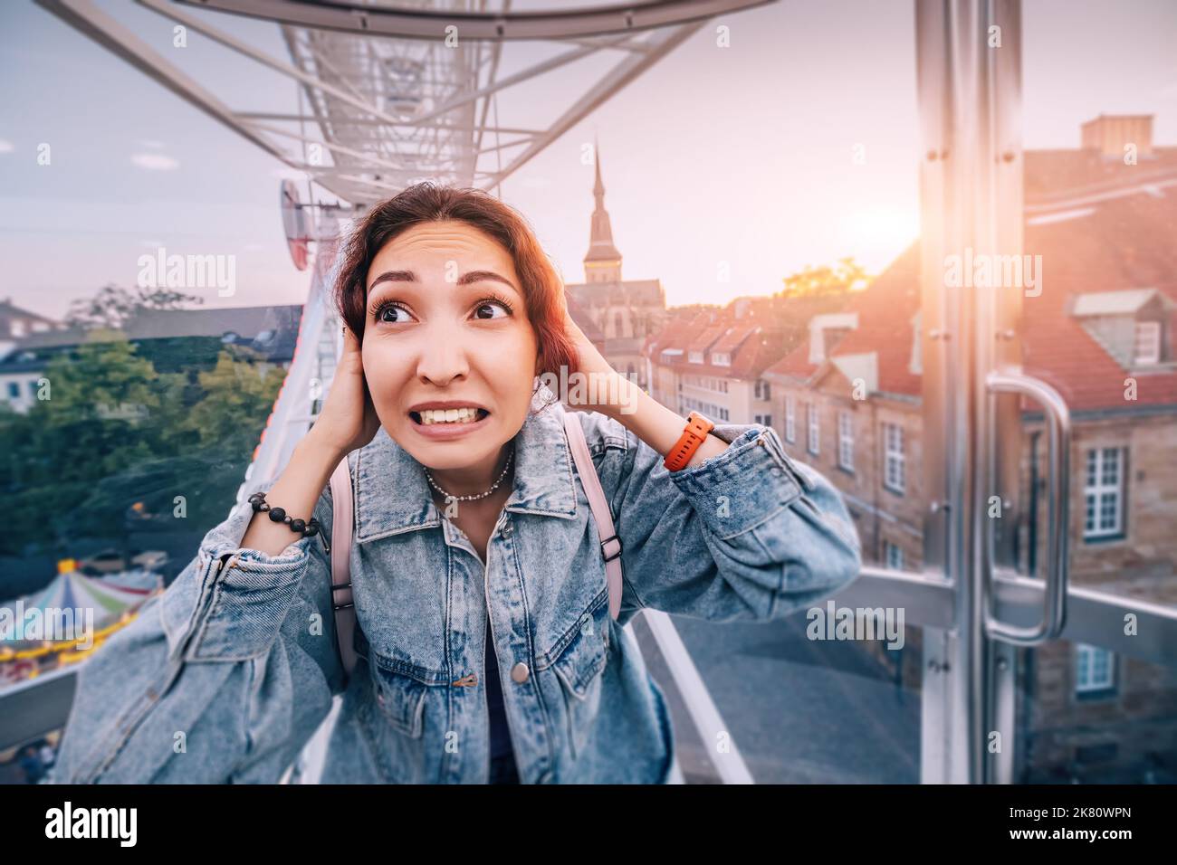 Ängstliches Mädchen im Riesenrad erlebt aufgrund der Höhenangst einen Panikanfall. Die Fahrt brach zusammen und blieb stecken. Psychologische Phobien und PR Stockfoto