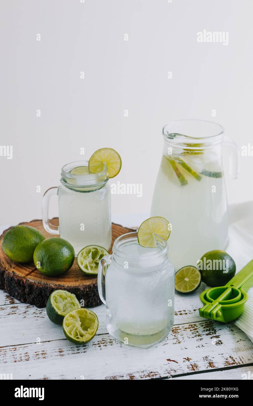 Glas Limonadengetränk mit grünen Zitronen oder Limette auf weißem Hintergrund in Lateinamerika Stockfoto