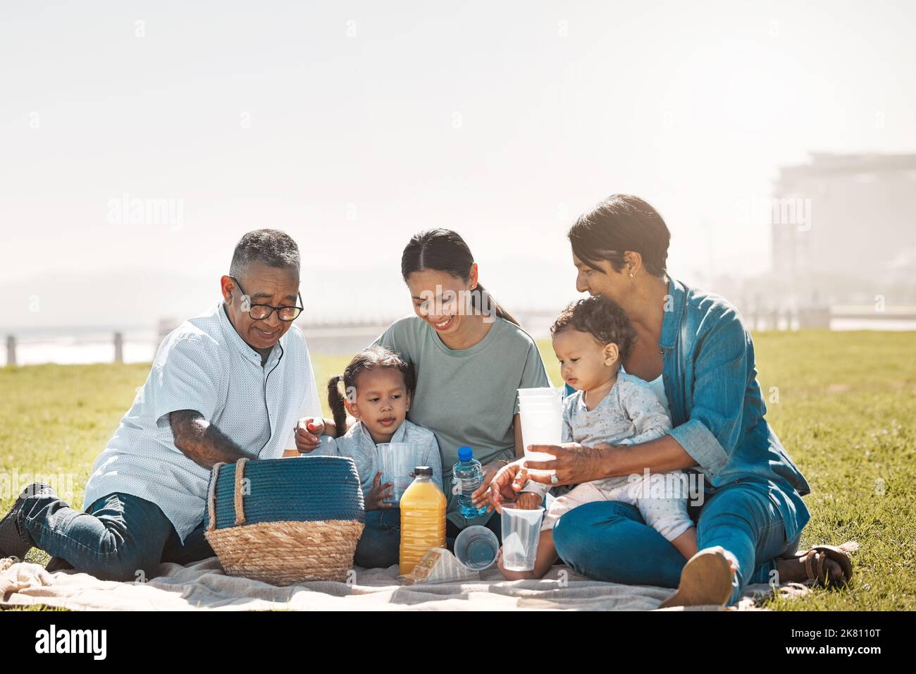 Entspannen, glücklich und Picknick mit der großen Familie im Park für Sommer, Natur und Essen zusammen auf Gras. Frühling, Ruhestand und Liebe mit Mutter, Kindern und Stockfoto