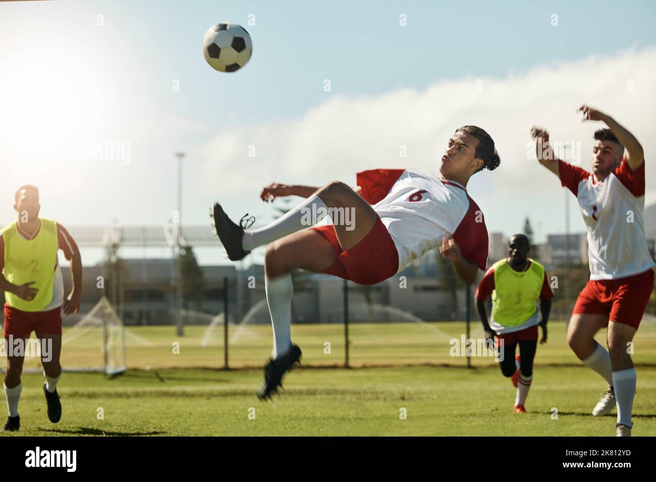 Fußballmannschaft, Mann und Ball treten beim Fußballspiel, Wettkampf oder Training in die Luft. Sport-, Fitness- und Fußballspieler auf dem Rasen zusammen in Stockfoto