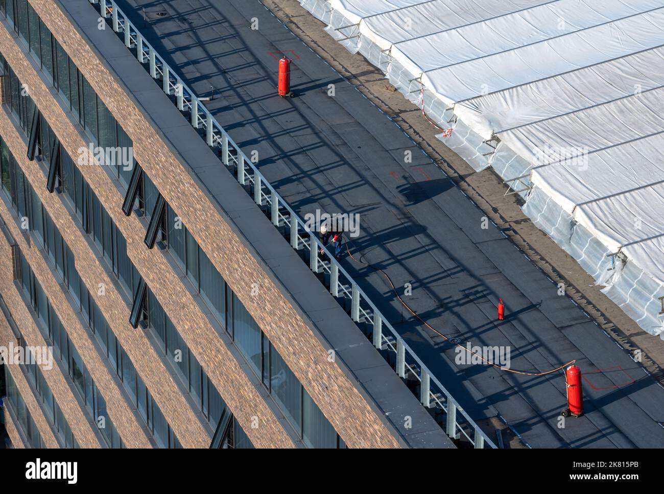 Vogelperspektive auf eine Dachbaustelle. Professionelle Bitumen-Abdichtung auf einem flachen Gebäude Stockfoto