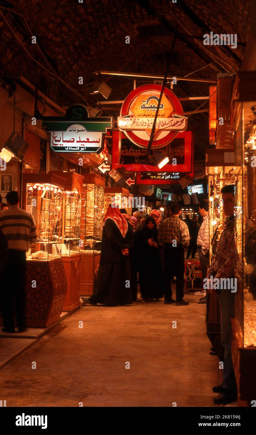 Syrien: Goldgeschäfte im Gold-Souk (Basar) im alten Großen Basar, Aleppo (1997). Der große Basar von Aleppo (auf Arabisch, suq oder suq) wurde zuerst von den ägyptischen Mamelukes, die die Mongolen vertrieben hatten, und dann, nach 1516, von den Türken, die Aleppo in das Osmanische Reich eingliederte, wieder aufgebaut. Während des syrischen Bürgerkrieges, der 2011 begann, erlitten die historischen Suqs von Aleppo schwere Schäden. Aleppo, die zweite Stadt Syriens, ist wahrscheinlich die längste kontinuierlich bewohnte Siedlung der Welt. Sein arabischer Name, Halab, wird in semitischen Texten des dritten Jahrtausends v. Chr. erwähnt. Stockfoto