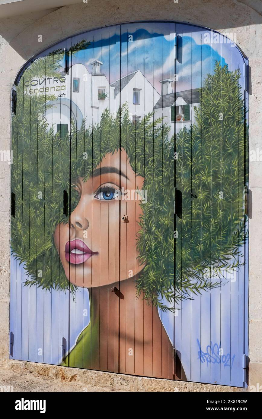 Gemälde von Mädchen mit afro-Stil Frisur auf Rollläden Türen, apulien, italien Stockfoto