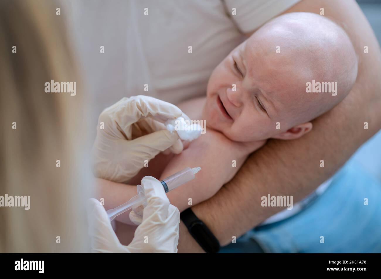 Kinderarzt, der den Impfstoff dem Neugeborenen injiziert Stockfoto