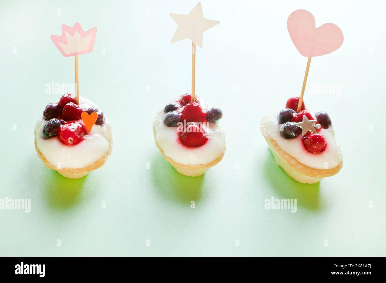 Mini-Kuchen mit Beeren und Hütte. Party-Dekoration mit Herzen. Geschenk zum Valentinstag für den Urlaub Stockfoto