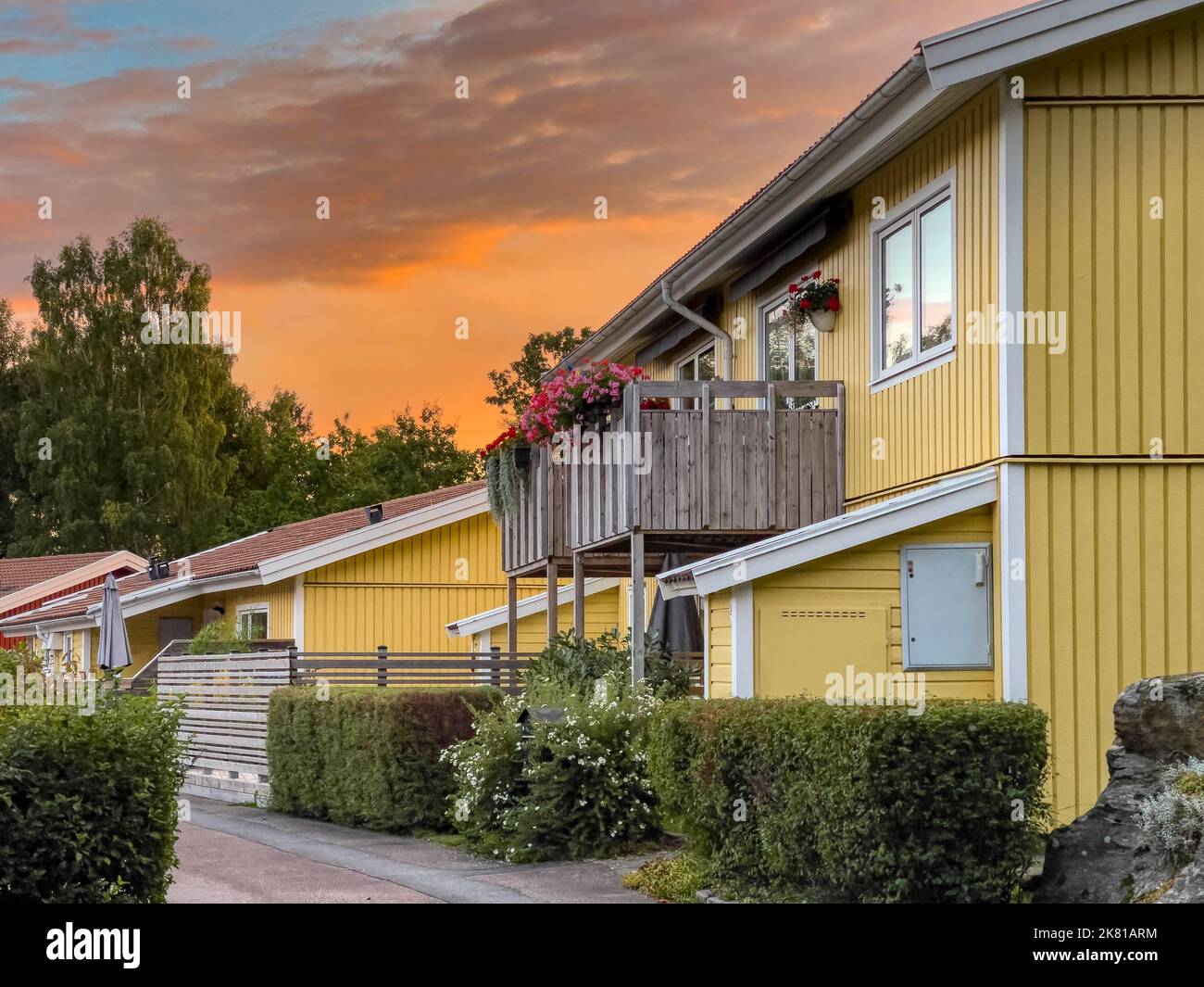 Typische traditionelle schwedische halbgetrennte, gelb bemalte Holzhäuser in einer Reihe in einer wunderschönen ruhigen Wohngegend Stockfoto