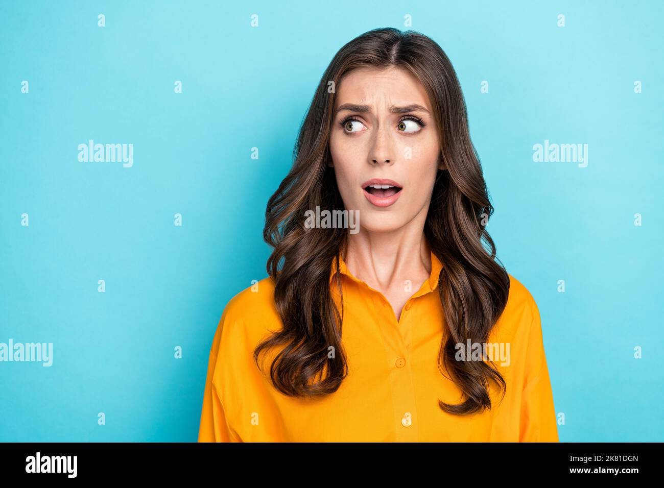 Foto-Porträt von charmanten jungen Dame Blick erschrocken leeren Raum tragen trendige gelbe smart casual Kleidung auf blauem Hintergrund isoliert Stockfoto