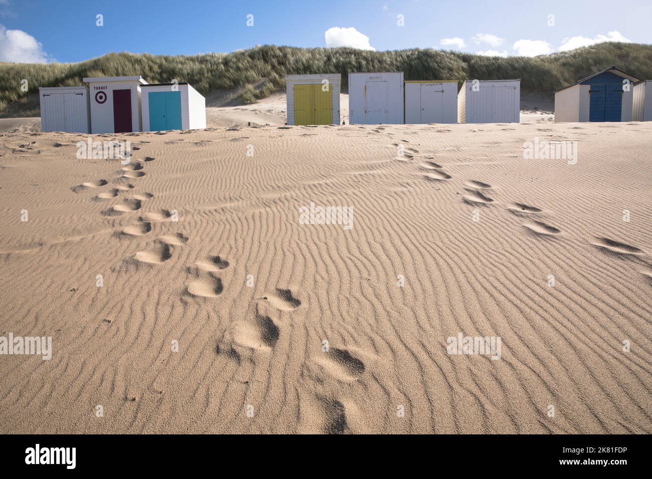 Strandhütten und Fußabdrücke am Strand in Oostkapelle auf der Halbinsel Walcheren, Zeeland, Niederlande. Strandhäuser und Fussspuren am Strand von Stockfoto