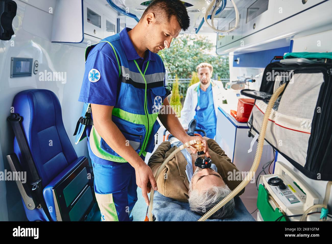 Erste Hilfe, Behandlung im Krankenwagen. Krankenwagen Pflegeassistent, der medizinische Hilfe mit künstlichen Lungen Beatmungsmaske für den Patienten im Krankenwagen bietet Stockfoto