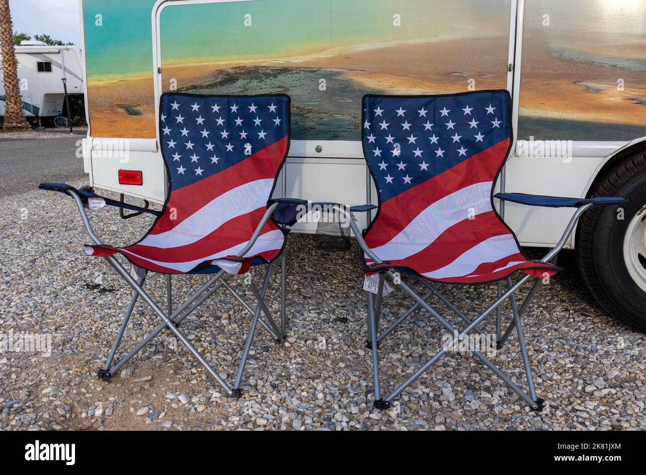 Zwei klappbare Campingstühle mit aufgedruckter amerikanischer Flagge, die in den Vereinigten Staaten vor einem Wohnmobil aufgestellt wurden Stockfoto