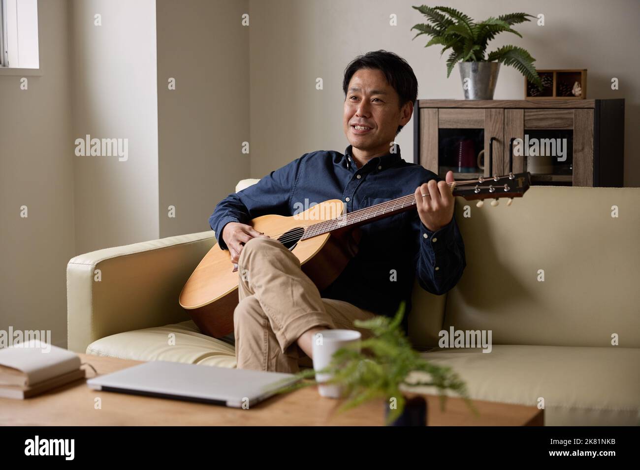 Japanischer Mann spielt akustische Gitarre Stockfoto