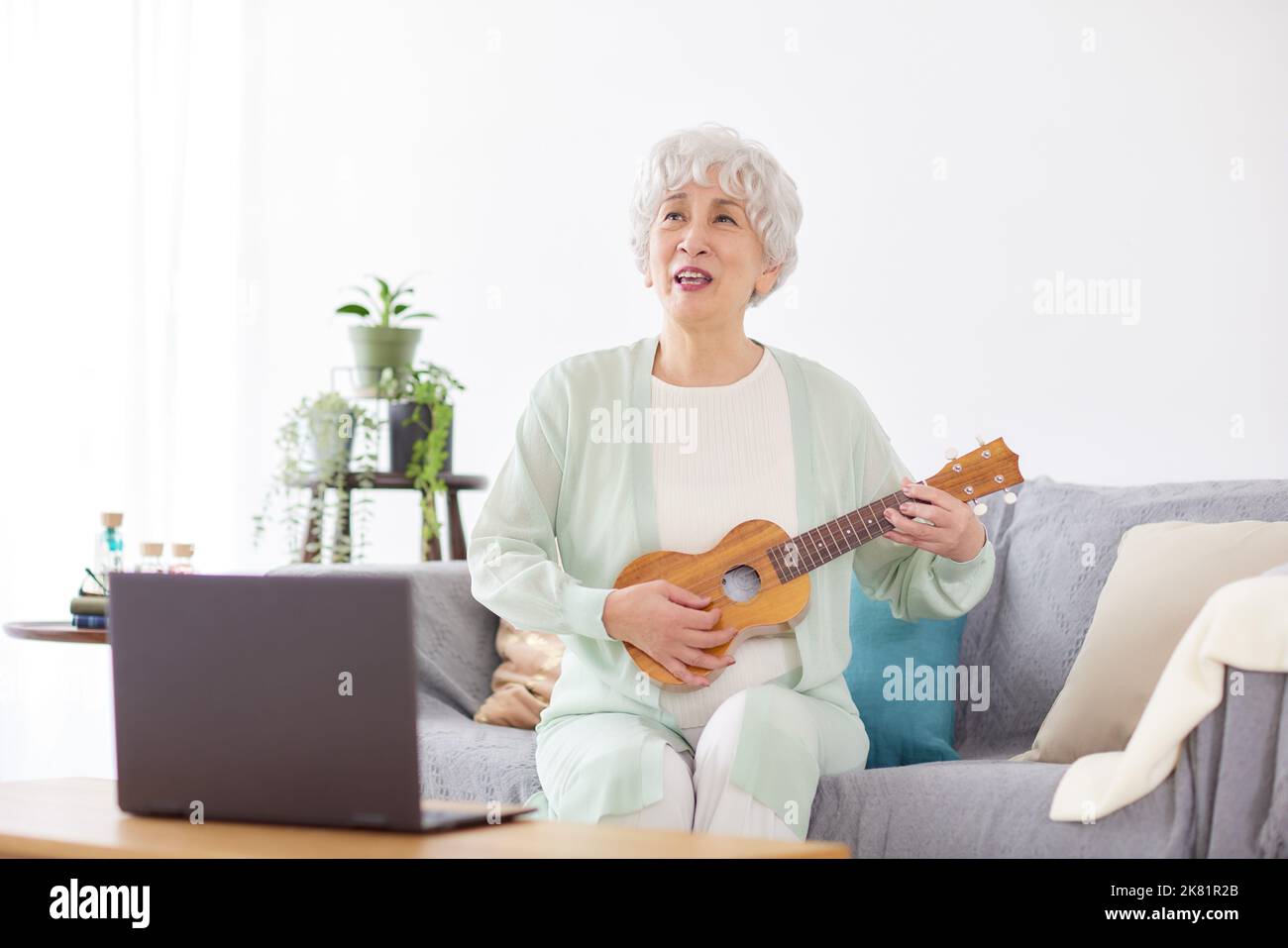 Japanische ältere Frau spielt Ukulele Stockfoto