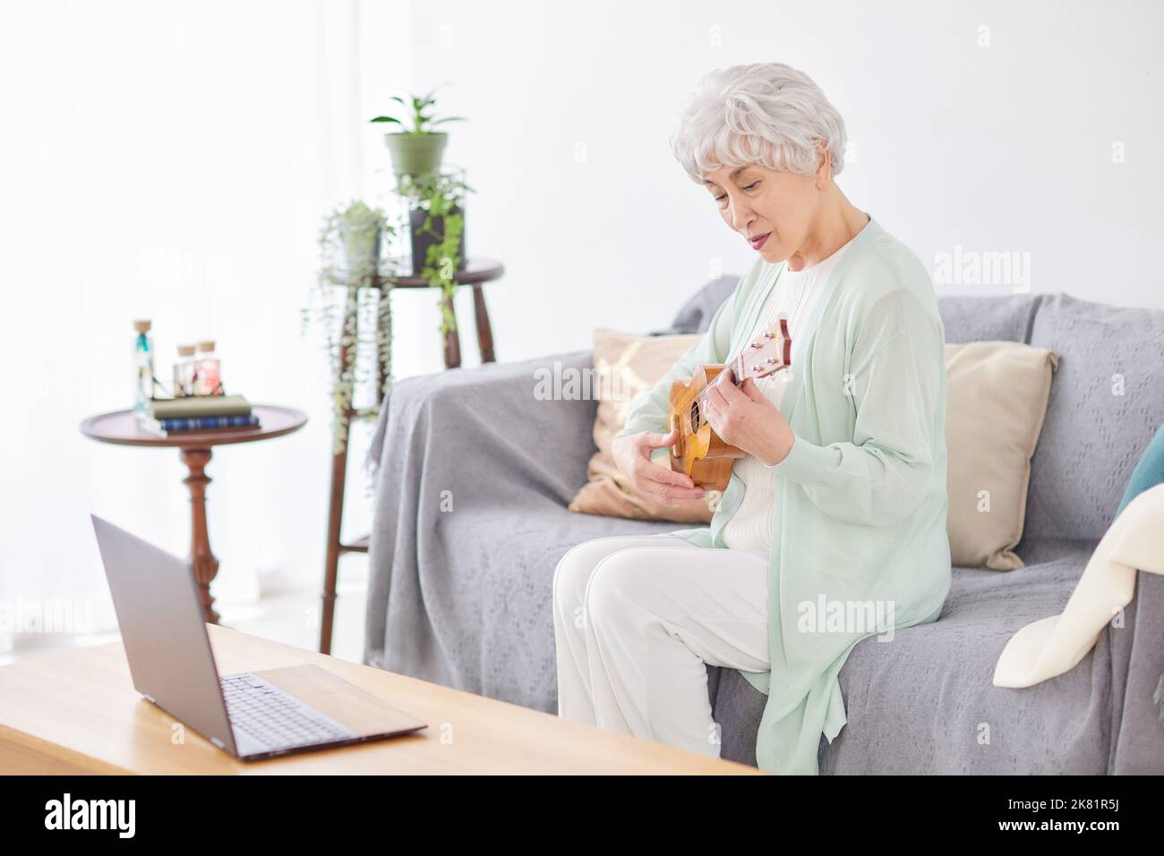 Japanische ältere Frau spielt Ukulele Stockfoto