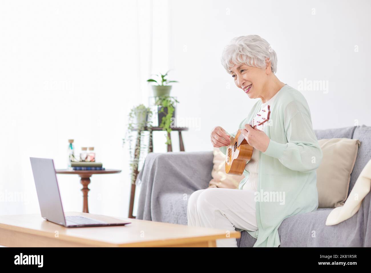 Japanische ältere Frau spielt Ukulele Stockfoto