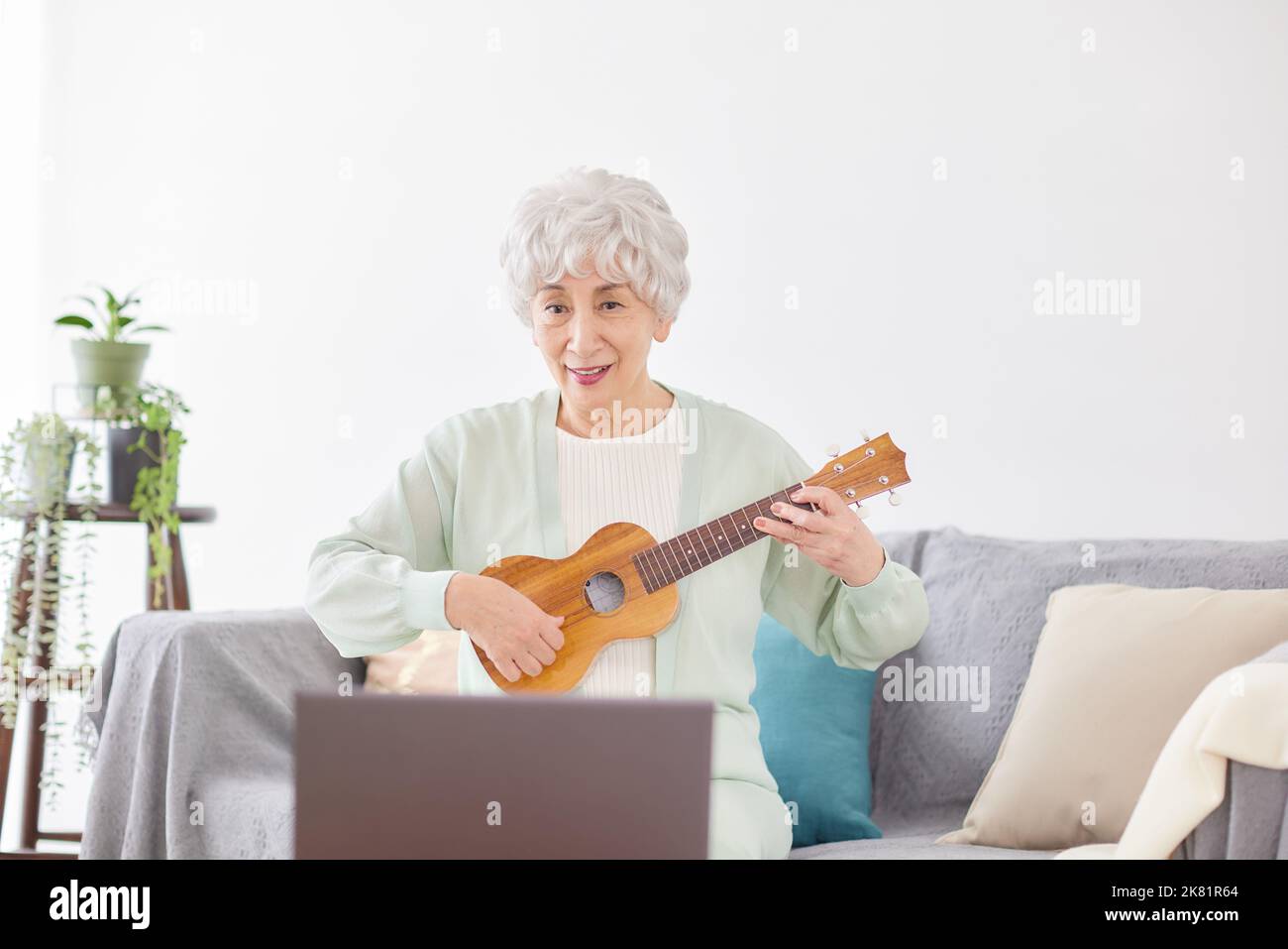 Japanische ältere Frau spielt Ukulele Stockfoto