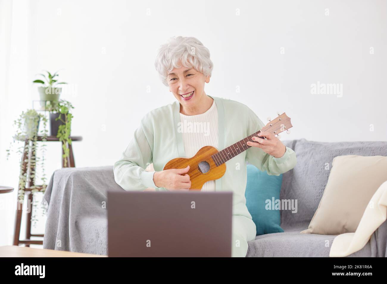 Japanische ältere Frau spielt Ukulele Stockfoto