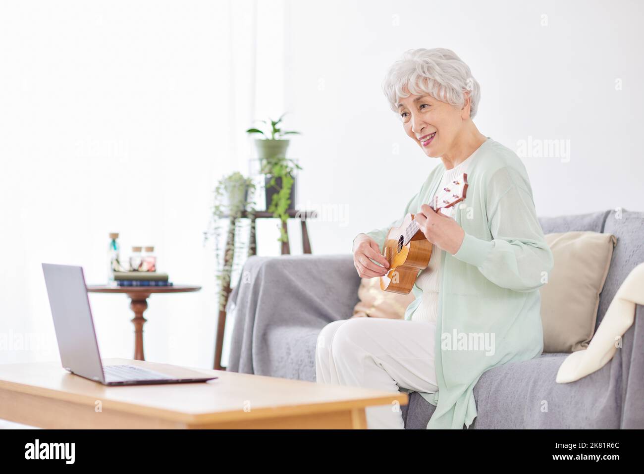 Japanische ältere Frau spielt Ukulele Stockfoto