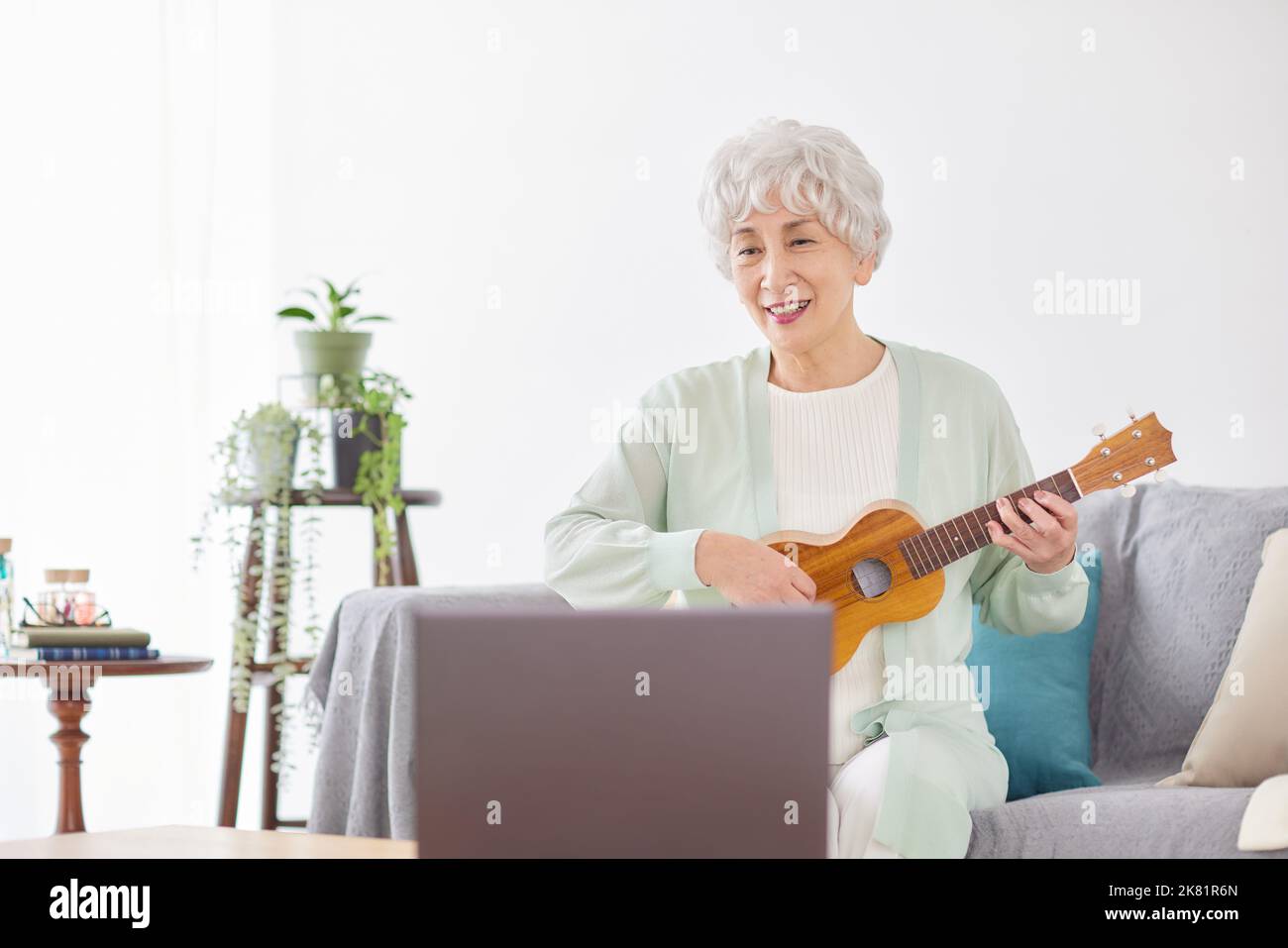 Japanische ältere Frau spielt Ukulele Stockfoto