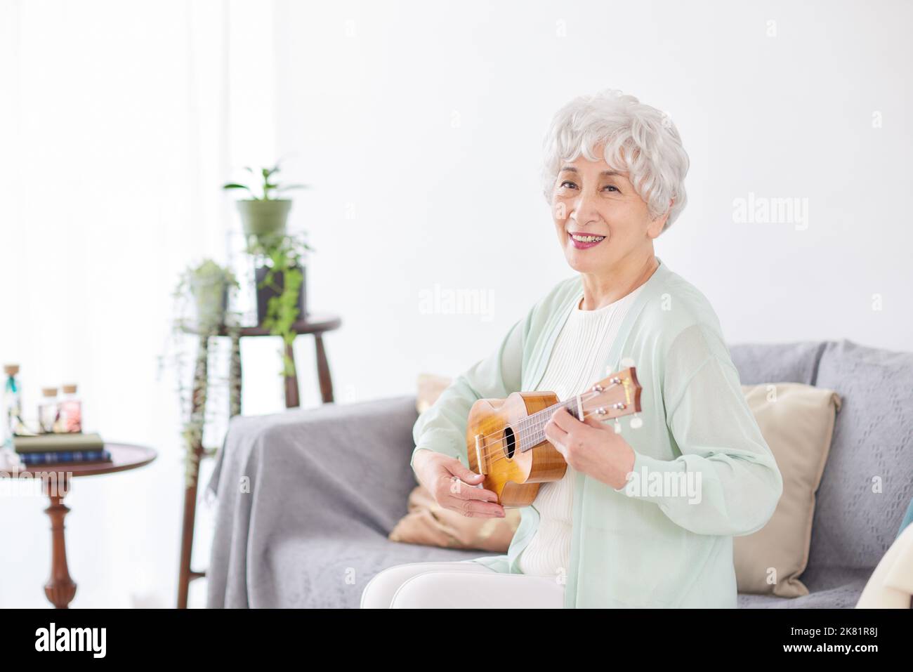 Japanische ältere Frau spielt Ukulele Stockfoto