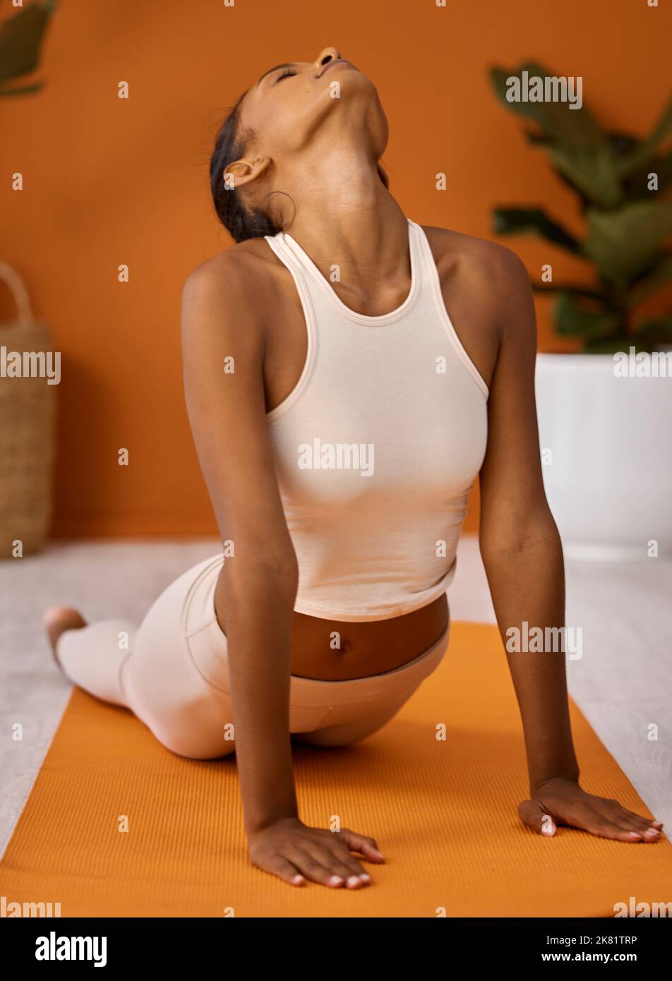 Diese Pose eignet sich hervorragend für Rückenschmerzen. Eine junge Frau, die sich während einer Yoga-Routine vor einem Studiohintergrund dehnt. Stockfoto