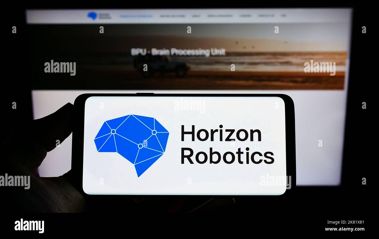 Person mit Mobiltelefon und Logo des chinesischen Automobilunternehmens Horizon Robotics Inc. Auf dem Bildschirm vor der Webseite. Konzentrieren Sie sich auf die Telefonanzeige. Stockfoto
