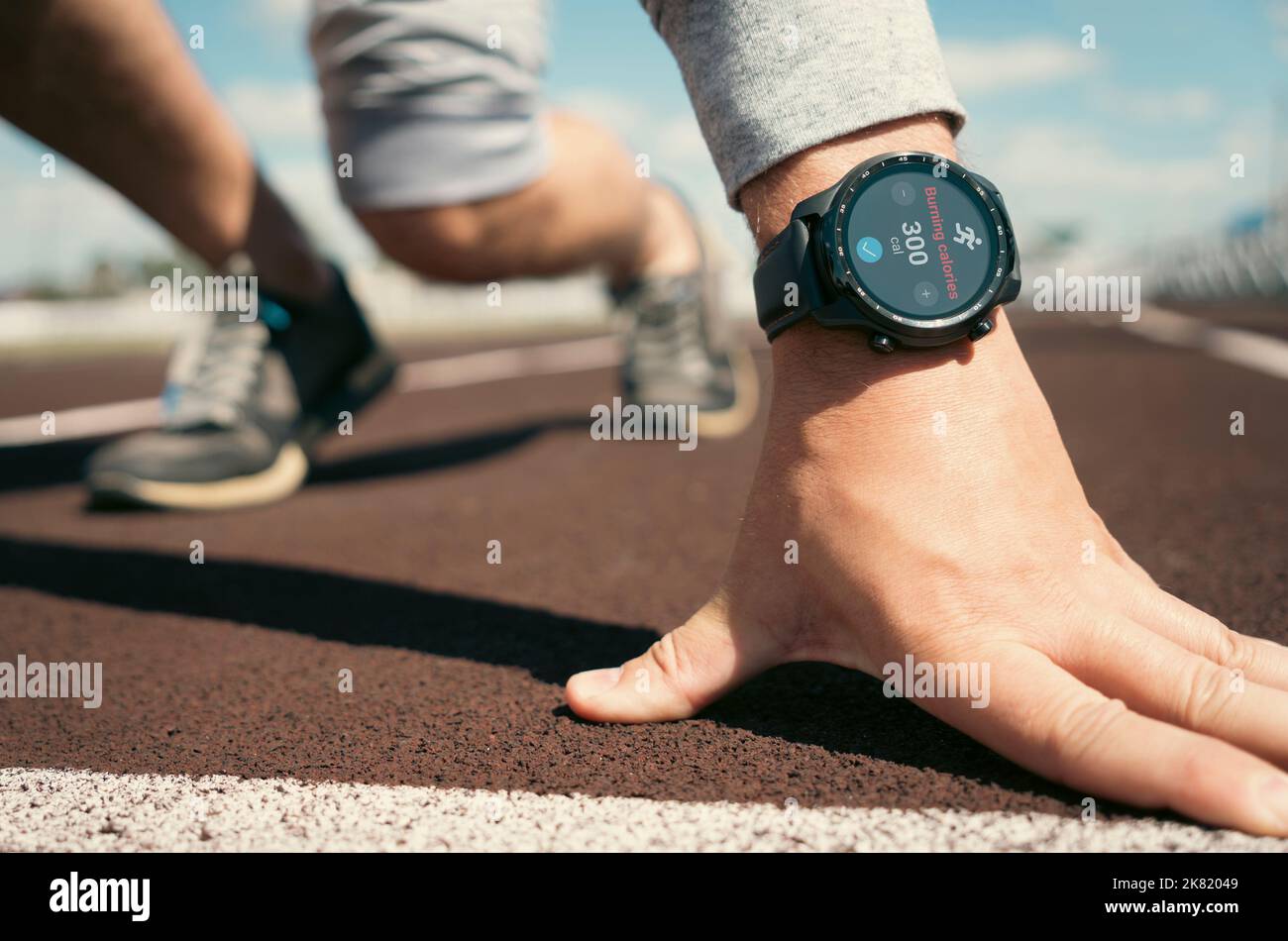 Ein Mann bereitet sich darauf vor, auf einem Laufband zu starten. Anwendungen für Smartwatch für das Outdoor-Training. Stockfoto