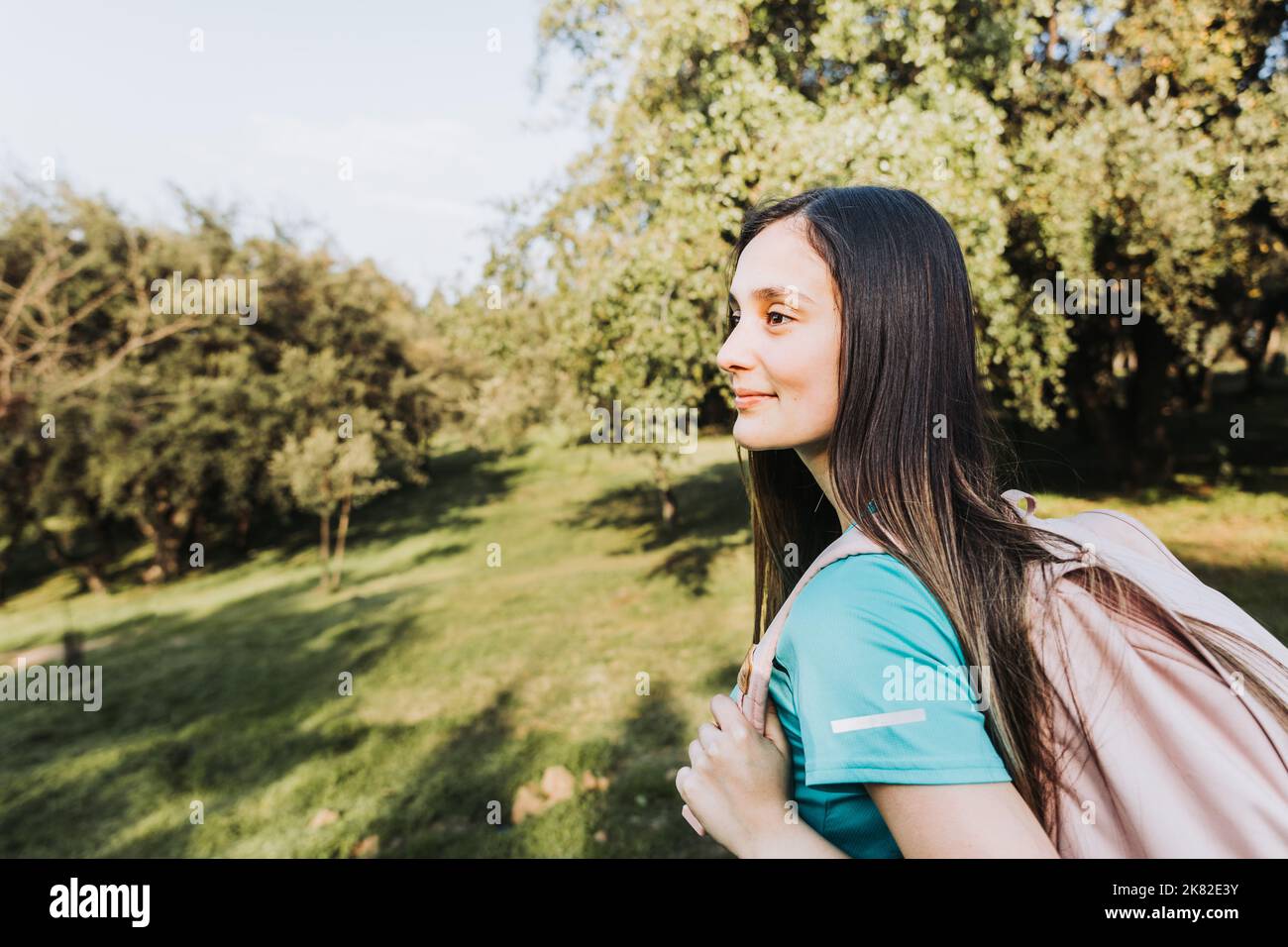 Seitenansicht junges Studentenmädchen mit rosa Rucksack Blick auf den Horizont vom Hügel. Selbstvertrauen. Stockfoto