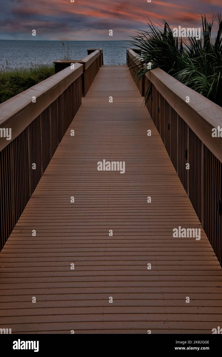 Fußgänger-Promenade, die sich bei Sonnenuntergang bis zum Amelia Beach, Florida erstreckt. Stockfoto