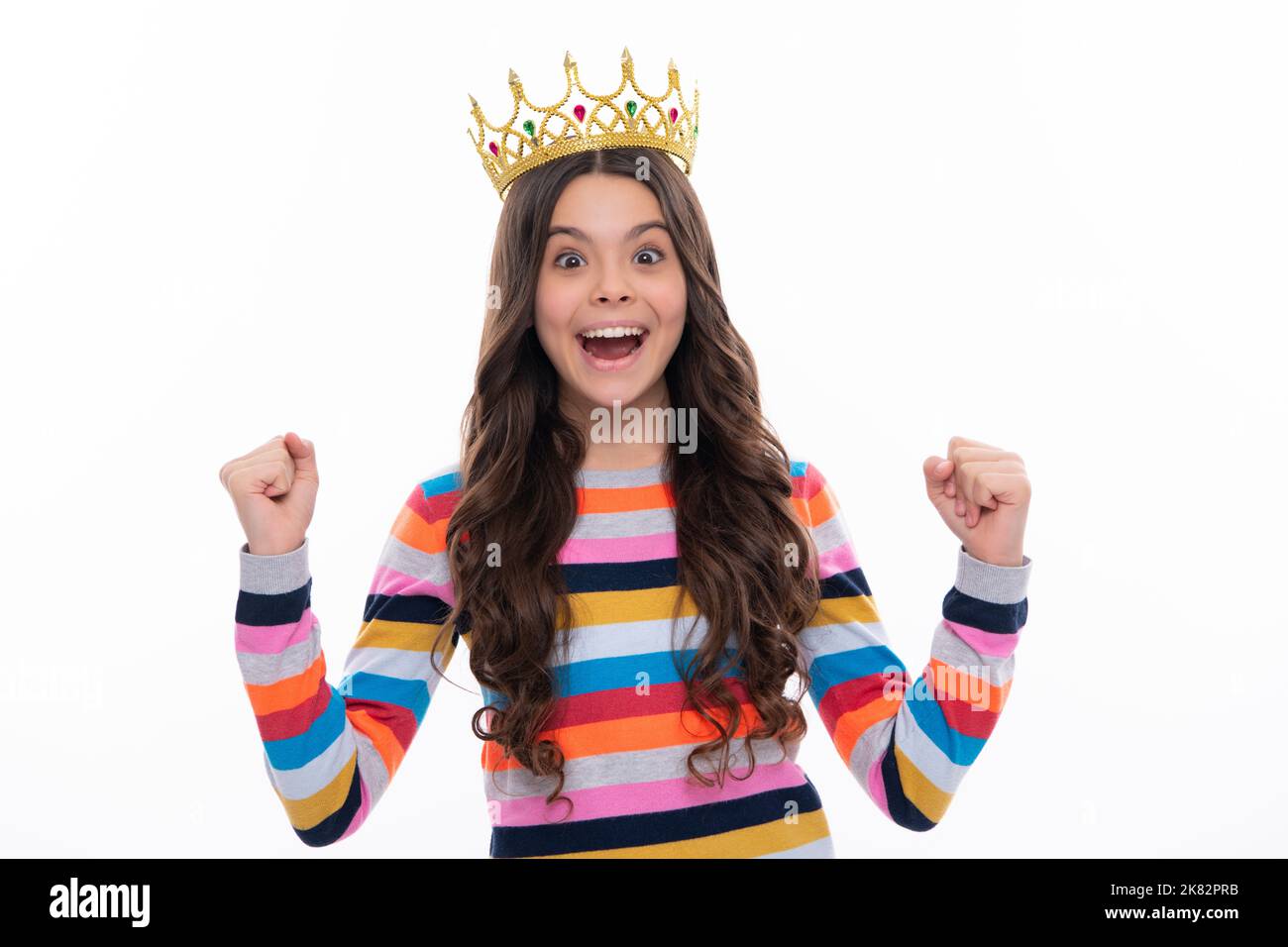 Porträt von ehrgeizigen Teenager-Mädchen mit Krone, Gefühl Prinzessin, Vertrauen. Kinderprinzessin Krone auf isoliertem Studiohintergrund. Aufgeregtes Gesicht Stockfoto