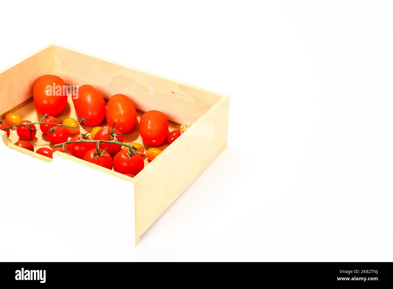 Frische reife gemischte Tomaten in einer Holzkiste mit Platz zum Kopieren Stockfoto