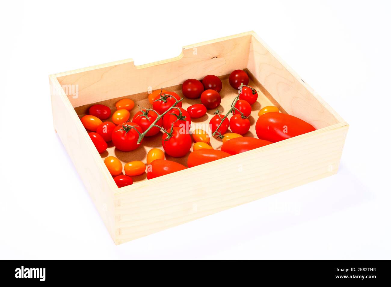 Frische reife gemischte Tomaten in einer Holzkiste Stockfoto