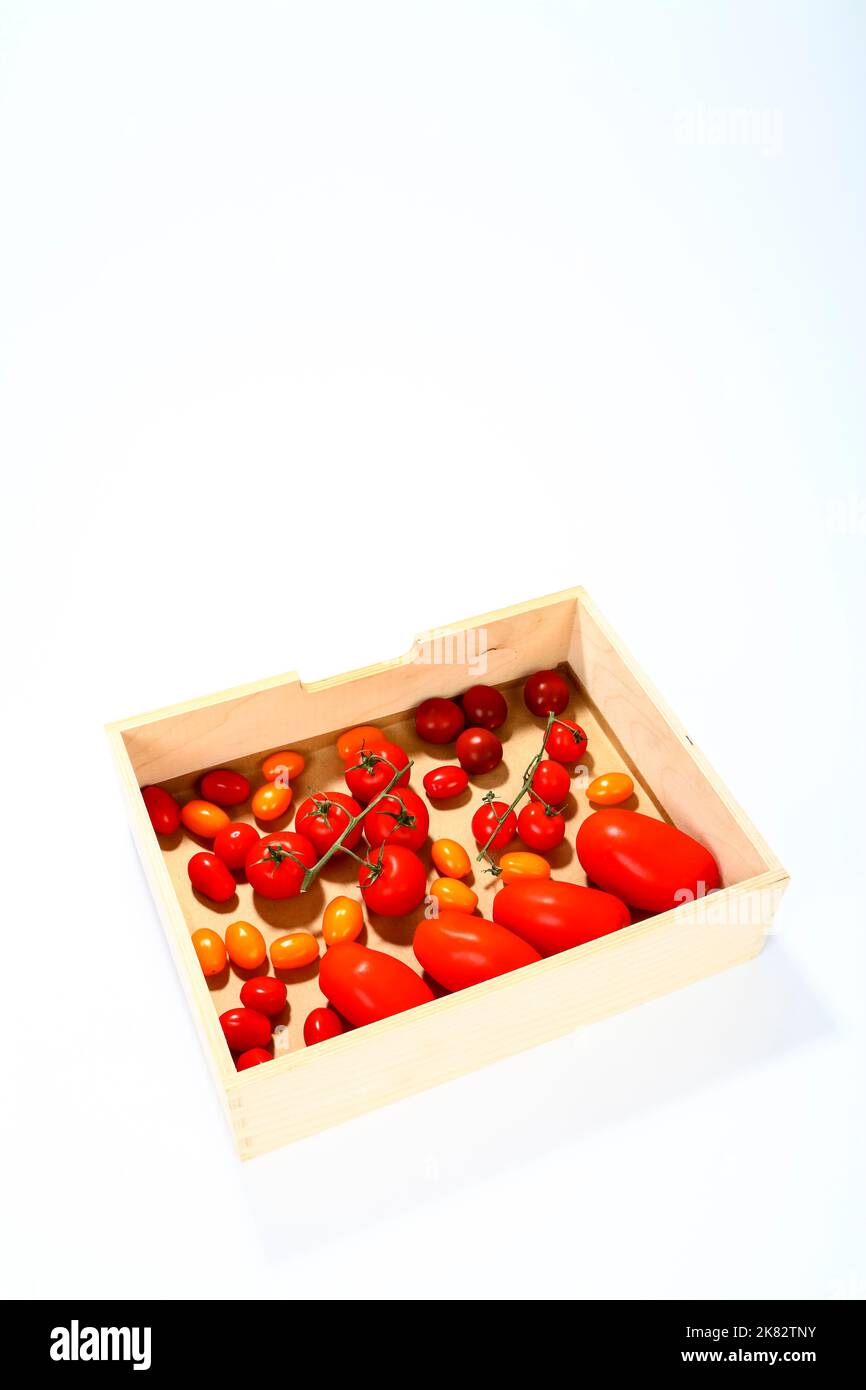 Frische reife gemischte Tomaten in einer Holzkiste mit Platz zum Kopieren Stockfoto