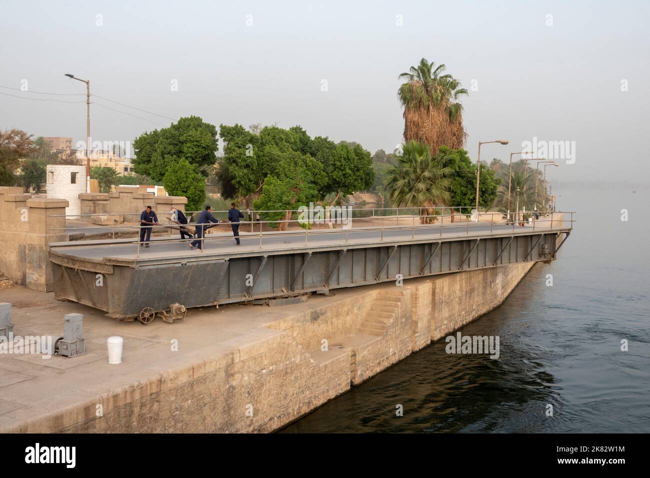 Vier Besatzungsmitglieder eines Nilkreuzfahrtschiffes wickeln manuell eine Schaukelbrücke Stockfoto