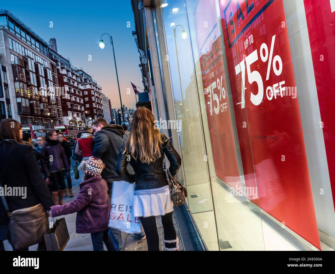Winterverkauf Brompton Road Knightsbridge, mit Menschenmassen und Schaufensterschild, die bis zu 75 % Rabatt bieten. Sonnenuntergang Dämmerung London Großbritannien Stockfoto
