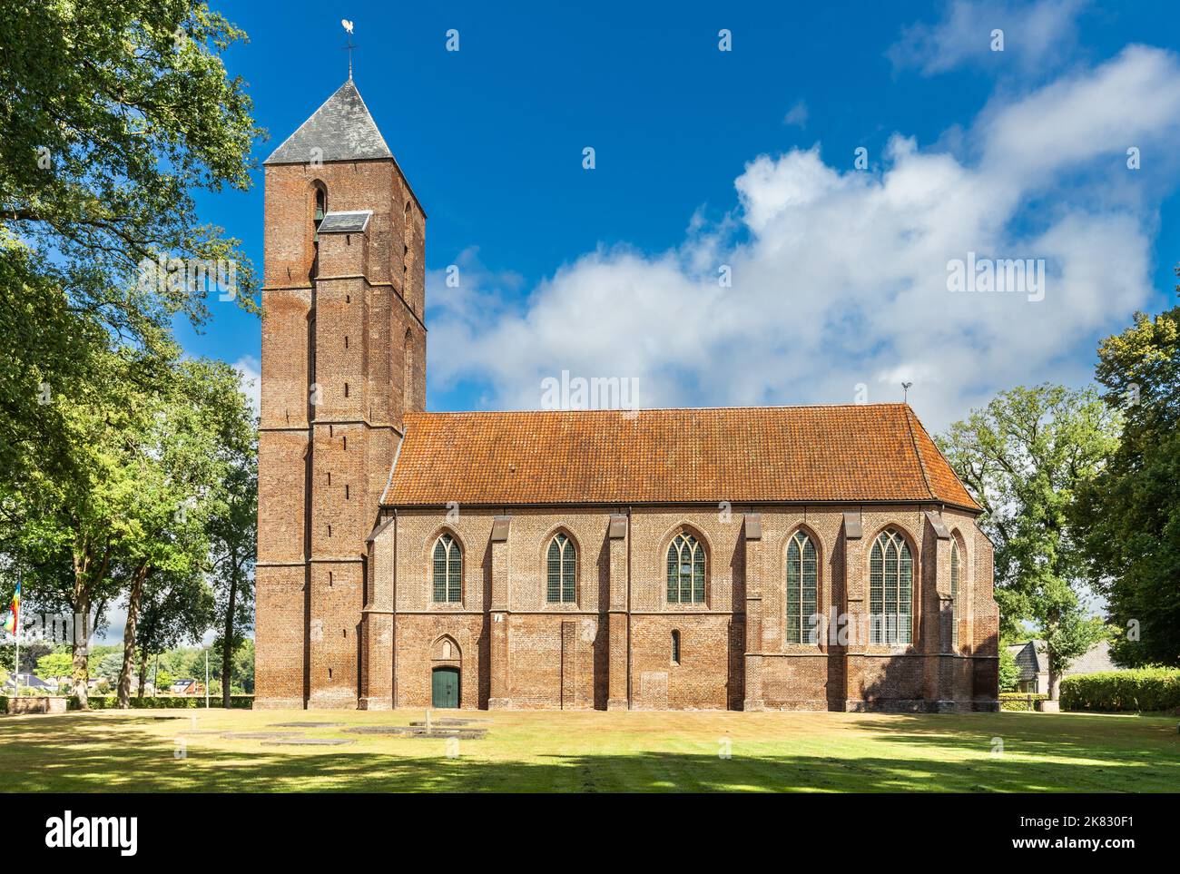 Sommerlandschaft mit historischem Wahrzeichen die Clemenskerk außerhalb des Dorfzentrums von Havelte in der niederländischen Provinz Drenthe, umgeben von alter Eiche Stockfoto