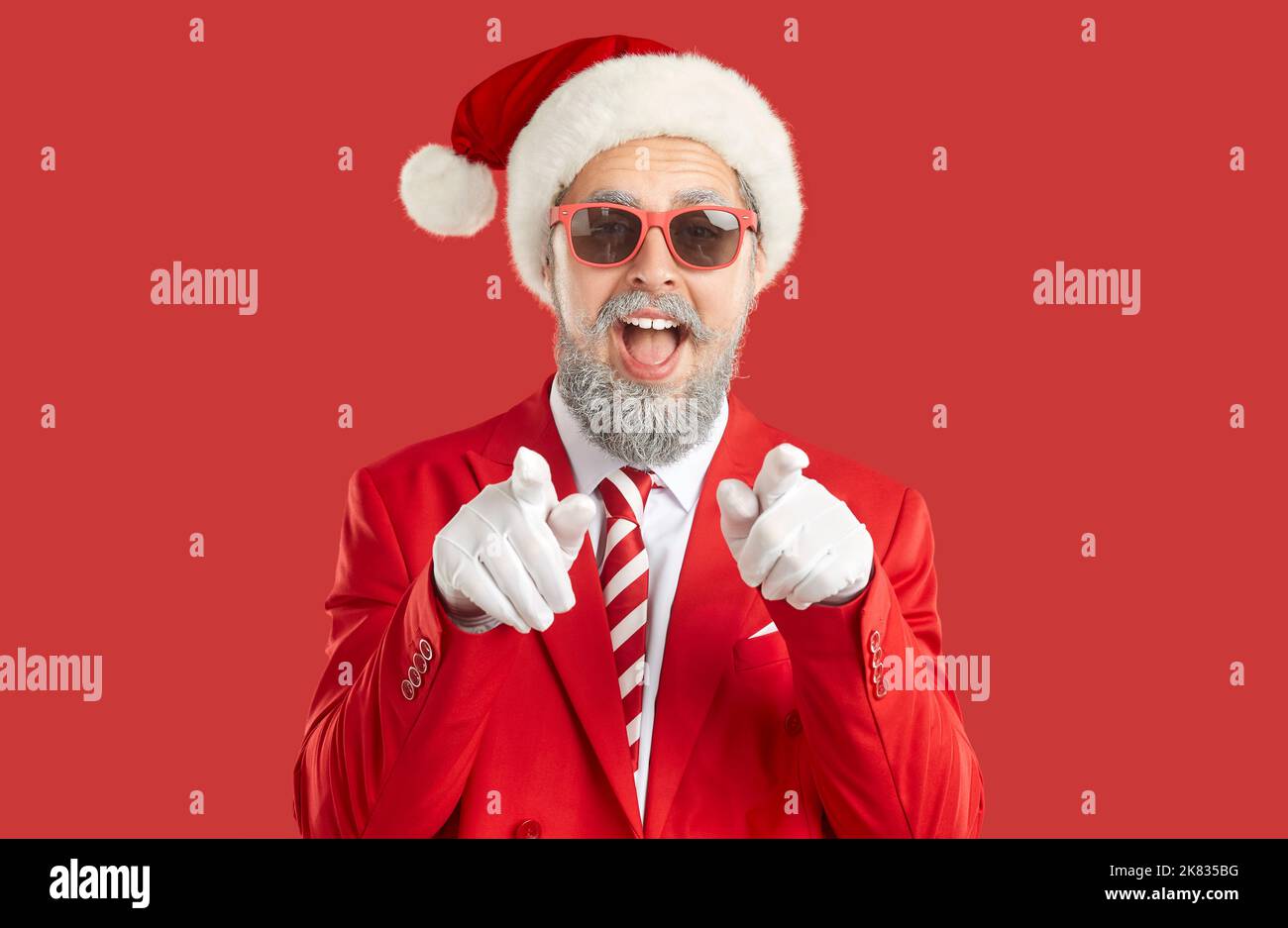 Fröhlicher Mann in Santa hat zeigt seine Finger auf Sie und fragt, ob Sie bereit für Silvester-Party sind Stockfoto
