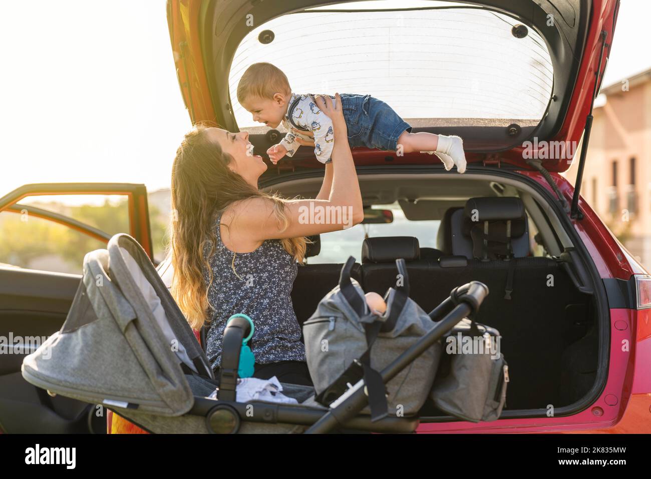 Mutter mit ihrem Sohn, der hinten im Auto spielt Stockfoto