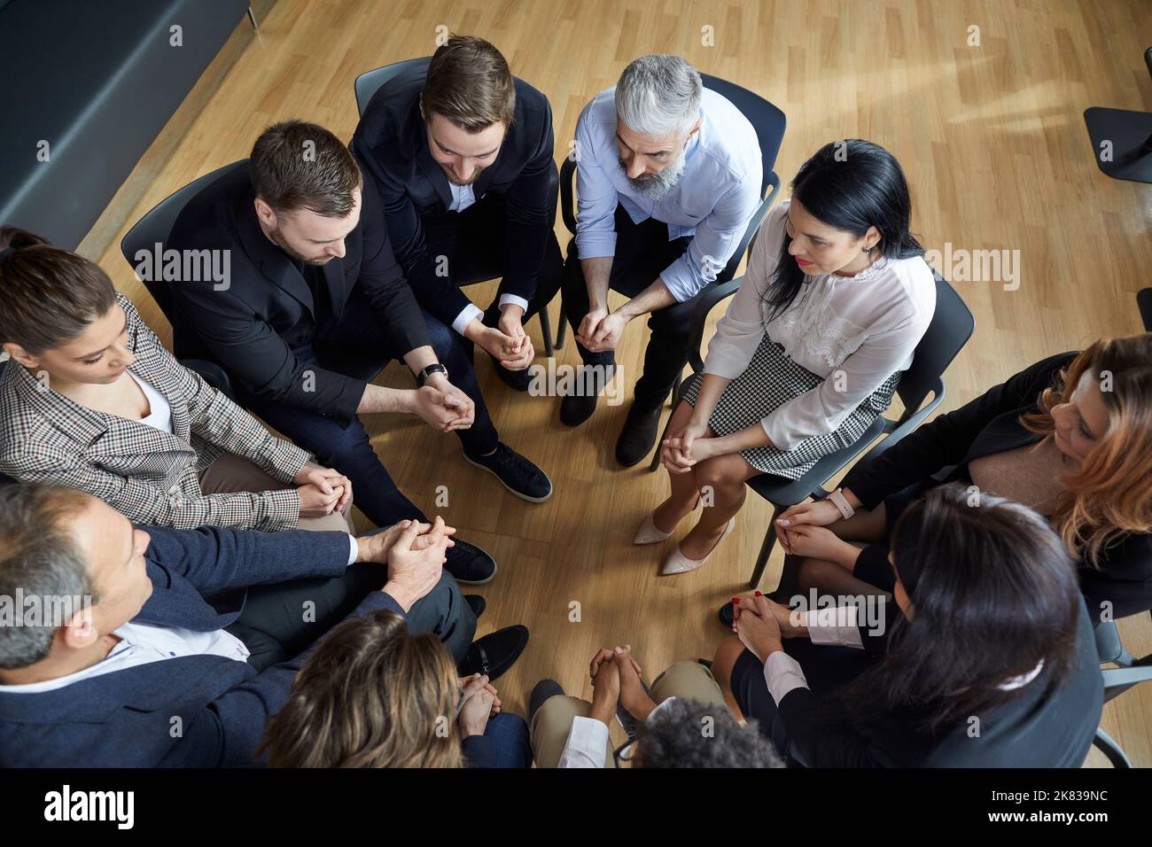 Geschäftsleute im Kreis sprechen während eines informellen Brainstormings oder während eines geschäftlichen Trainings. Stockfoto