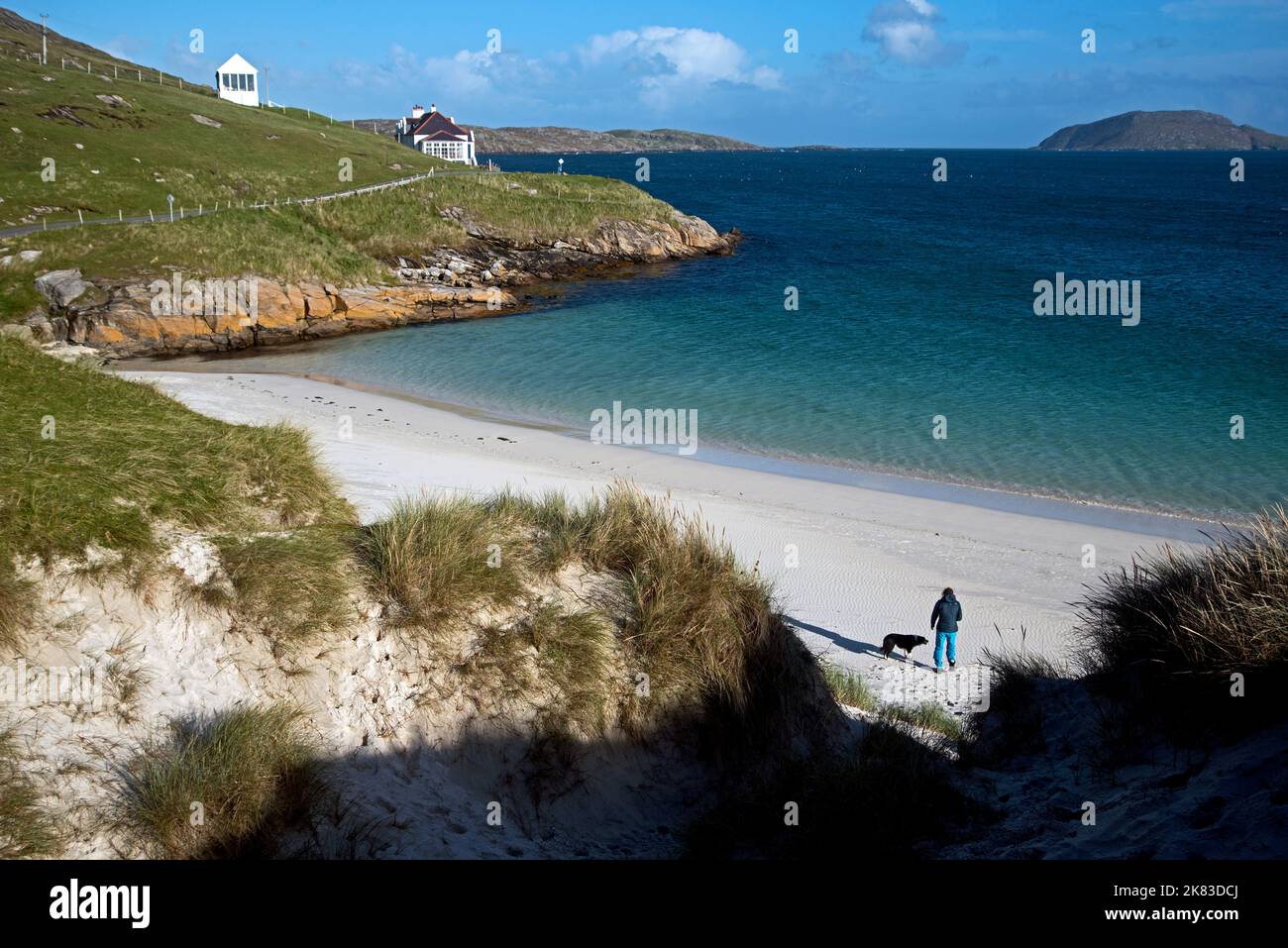 Junge Frau mit Hund auf Traigh a Bhaigh (East Beach), in der Nähe des Startens des Hebriden Way auf Vatersay in den Äußeren Hebriden, Schottland, Großbritannien. Stockfoto