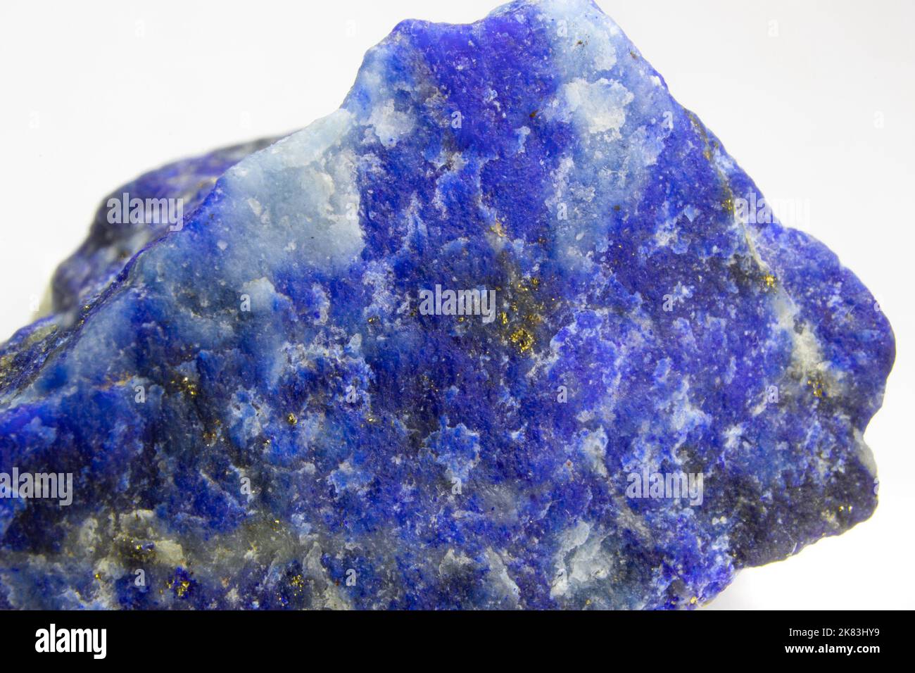 Roher Lapislazuli-Felsen auf weißem Hintergrund. Unpoliertes Stück Lapislazuli auf weißem Hintergrund. Lapislazuli mit Pyritflecken. Stockfoto