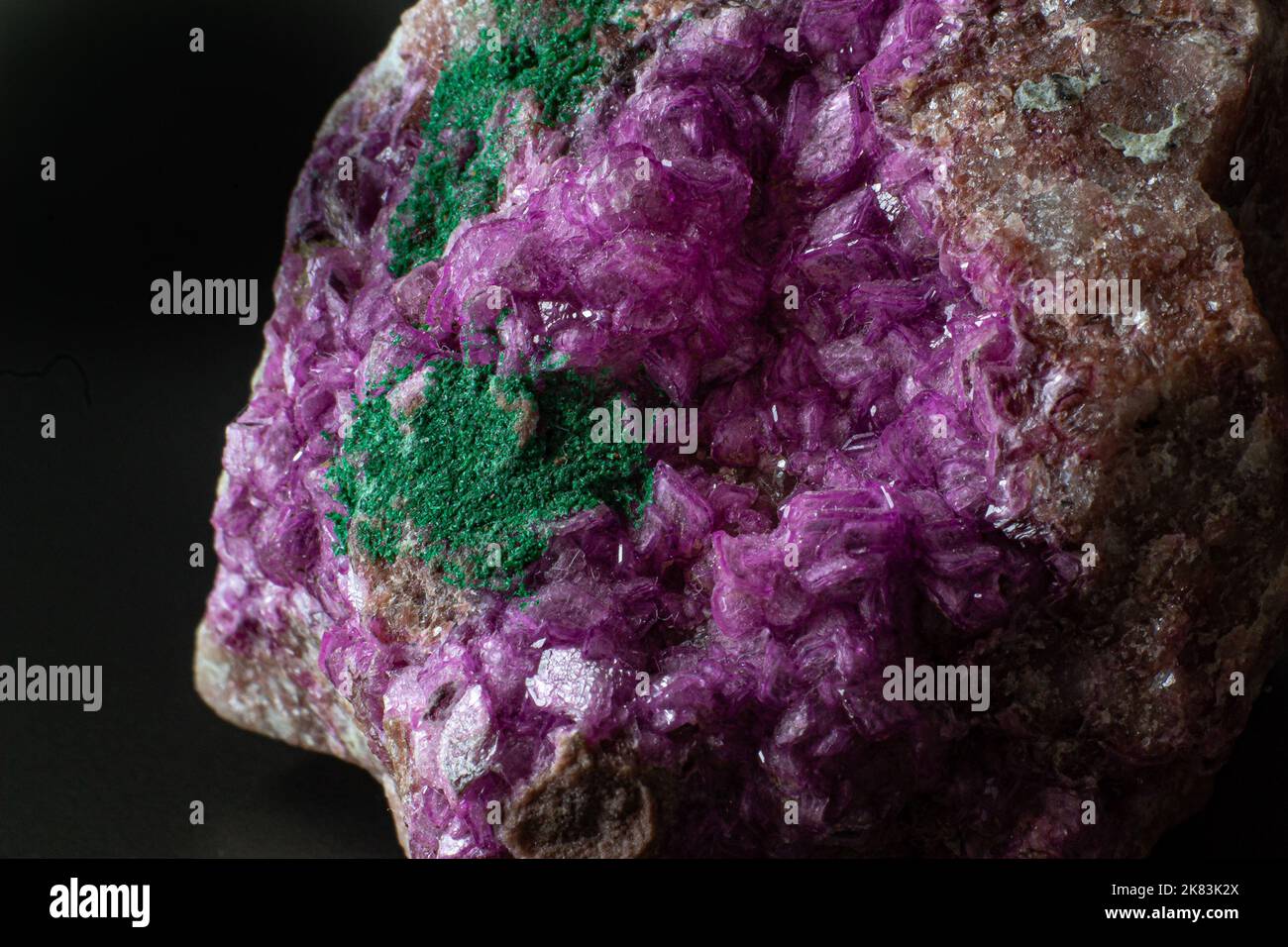 Cobalto-Calcit mit Malachit-Kristallmakro auf einer schwarzen Oberfläche Stockfoto